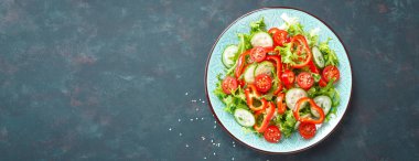 Sağlıklı vejetaryen sebze salatası, taze marul, salatalık, tatlı biber ve domates. Vegan gıda bitkisel kökenli. Düz yatıyordu. Üstten görünüm. Afiş