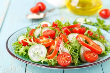 Sağlıklı vejetaryen sebze salatası, taze marul, salatalık, tatlı biber ve domates. Vegan bitkisel kökenli gıda