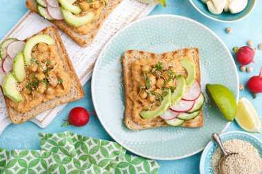 Nohut Humus, avokado, taze turp, salatalık, susam ve keten tohumu lahanası kızartır. Diyet kahvaltı. Lezzetli ve sağlıklı Bitkisel kökenli, vegan gıda vejetaryen. Düz yatıyordu. Üstten görünüm