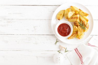 Fırında patates ve Domates ketçap beyaz tabak, ahşap arka plan, üstten görünüm