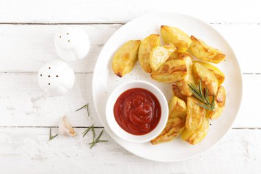 Fırında patates ve Domates ketçap beyaz tabak, ahşap arka plan, üstten görünüm