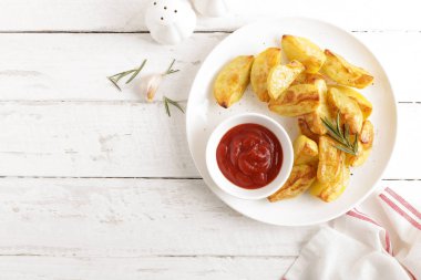 Fırında patates ve Domates ketçap beyaz tabak, ahşap arka plan, üstten görünüm