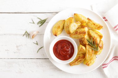 Fırında patates ve Domates ketçap beyaz tabak, ahşap arka plan, üstten görünüm