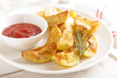 Fırında patates ve beyaz kaplama, ahşap arka plan Domates ketçap