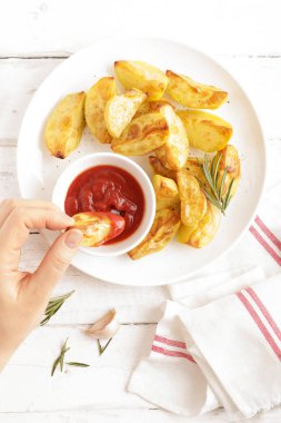 Fırında patates ve Domates ketçap beyaz tabak, ahşap arka plan, üstten görünüm