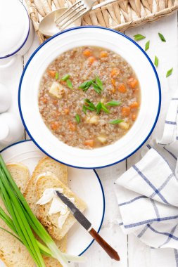 Buğday çorbası ile havuç ve patates Beyaz ahşap rustik masa üzerinde. Sağlıklı vejetaryen yemek, üstten görünüm