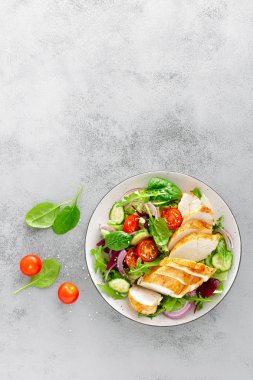 Izgara tavuk göğsü, fileto ve taze sebze salatası marul, roka, ıspanak, salatalık ve domates. Sağlıklı öğle yemeği menüsü. Diyet yemekleri. Üstten görünüm