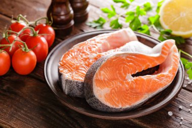 Ahşap rustik masa portre üzerinde biftek pişirme iki taze çiğ Somon Balık