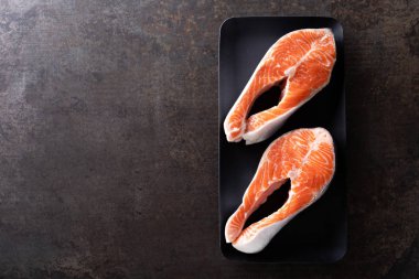 Biftek siyah arka plan üstten görünüm üzerinde taze somon balık