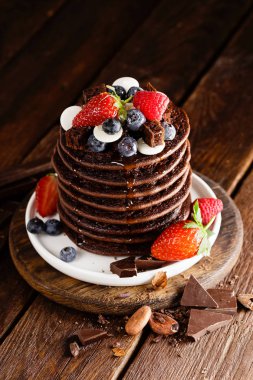 Yığın çikolata çilek, çilek, ahududu ve yaban mersinli krep