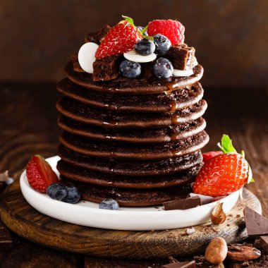 Yığın çikolata çilek, çilek, ahududu ve yaban mersinli krep