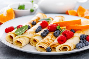 Tatlı krep taze çilek ile sarılmış yaban mersini ve ahududu kahvaltıda krep