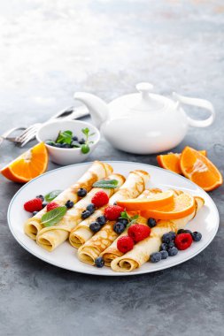 Tatlı krep taze çilek ile sarılmış yaban mersini ve ahududu kahvaltıda krep