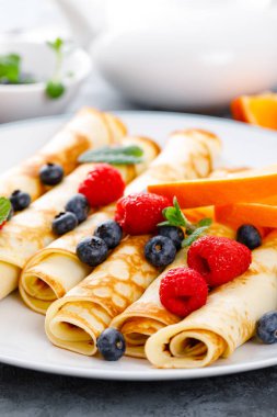 Tatlı krep taze çilek ile sarılmış yaban mersini ve ahududu kahvaltıda krep