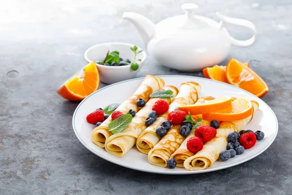 Tatlı krep taze çilek ile sarılmış yaban mersini ve ahududu kahvaltıda krep