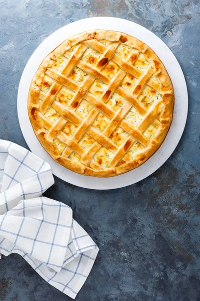 Pie with salted soft cheese and greens, top view