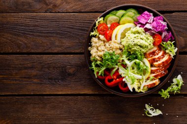 Buda kase yemek. Sağlıklı dengeli yemek quinoa, ızgara tavuk eti, marul salatası, biber, salatalık, domates ve avokado guacamole limon ile