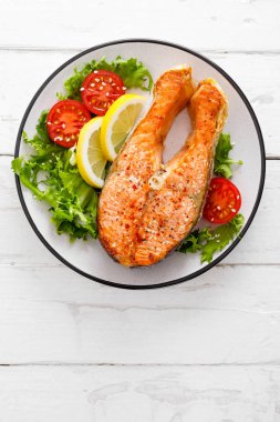 Somon balık ızgara biftek ve taze sebze salata domates ve marul. Sağlıklı gıda. Üstten görünüm