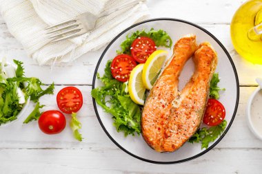 Somon balık ızgara biftek ve taze sebze salata domates ve marul. Sağlıklı gıda. Üstten görünüm