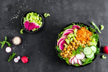 Salata Buda kase taze salatalık, kereviz, karpuz turp, çiğ havuç, marul, turp ve nohut öğle yemeği için. Sağlıklı vejetaryen yemek. Vegan sebze tabağı. Üstten görünüm