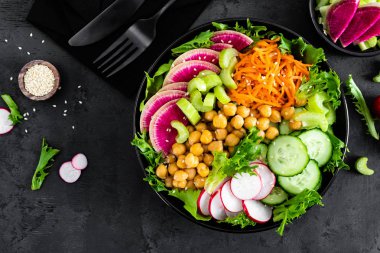 Salata Buda kase taze salatalık, kereviz, karpuz turp, çiğ havuç, marul, turp ve nohut öğle yemeği için. Sağlıklı vejetaryen yemek. Vegan sebze tabağı. Üstten görünüm