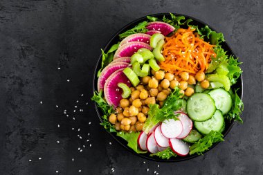 Salata Buda kase taze salatalık, kereviz, karpuz turp, çiğ havuç, marul, turp ve nohut öğle yemeği için. Sağlıklı vejetaryen yemek. Vegan sebze tabağı. Üstten görünüm