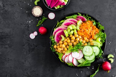 Salata Buda kase taze salatalık, kereviz, karpuz turp, çiğ havuç, marul, turp ve nohut öğle yemeği için. Sağlıklı vejetaryen yemek. Vegan sebze tabağı. Üstten görünüm