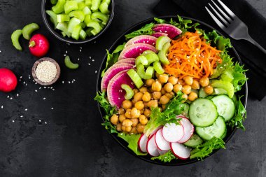 Salata Buda kase taze salatalık, kereviz, karpuz turp, çiğ havuç, marul, turp ve nohut öğle yemeği için. Sağlıklı vejetaryen yemek. Vegan sebze tabağı. Üstten görünüm