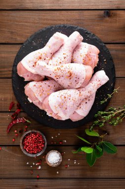 Ahşap arka plan üzerinde ham taze tavuk budu. Üstten görünüm