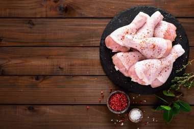 Ahşap arka plan üzerinde ham taze tavuk budu. Üstten görünüm