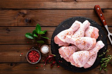 Ahşap arka plan üzerinde ham taze tavuk budu. Üstten görünüm