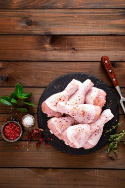 Ahşap arka plan üzerinde ham taze tavuk budu. Üstten görünüm