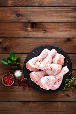 Ahşap arka plan üzerinde ham taze tavuk budu. Üstten görünüm