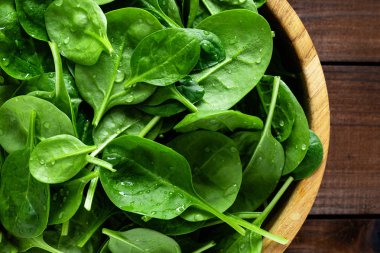 Taze ıspanak ahşap arka plan üzerinde bırakır. Sağlıklı vegan gıda. Top vie