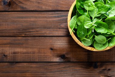 Taze ıspanak ahşap arka plan üzerinde bırakır. Sağlıklı vegan gıda. Top vie