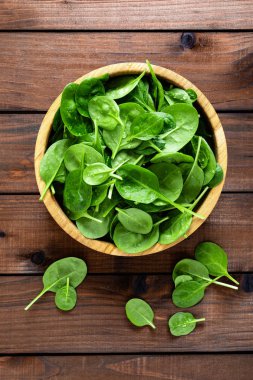 Taze ıspanak ahşap arka plan üzerinde bırakır. Sağlıklı vegan gıda. Top vie