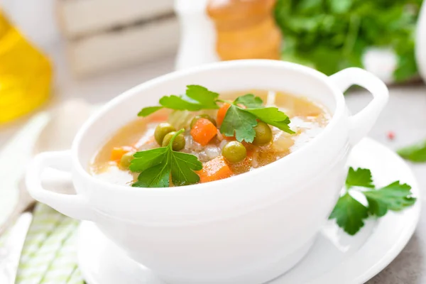 夏の軽いベジタリアン野菜ニンジン ジャガイモ キャベツ グレーン入りスープ白い背景のエンドウ豆 ダイエット健康的でおいしいランチ 離乳食 — ストック写真
