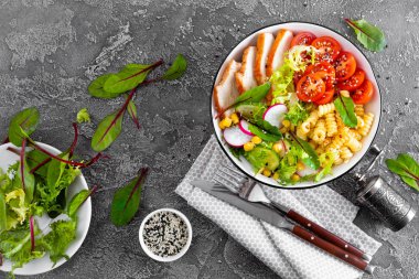 Izgara tavuk eti taze sebze salatası, domates, salatalık, turp, marul, pazı yaprakları, Mısır ve makarna ile. Sağlıklı öğle yemeği menüsü. Üstten Görünüm