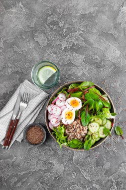 Buda kase yemek buğday lapası, haşlanmış yumurta, taze sebze salatası, turp, salatalık, marul ve pazı yaprakları. Sağlıklı öğle yemeği menüsü. Üstten Görünüm