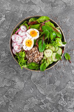 Buda kase yemek buğday lapası, haşlanmış yumurta, taze sebze salatası, turp, salatalık, marul ve pazı yaprakları. Sağlıklı öğle yemeği menüsü. Üstten Görünüm