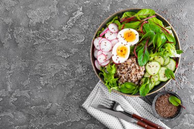 Buda kase yemek buğday lapası, haşlanmış yumurta, taze sebze salatası, turp, salatalık, marul ve pazı yaprakları. Sağlıklı öğle yemeği menüsü. Üstten Görünüm