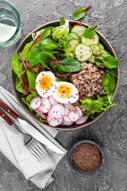 Buda kase yemek buğday lapası, haşlanmış yumurta, taze sebze salatası, turp, salatalık, marul ve pazı yaprakları. Sağlıklı öğle yemeği menüsü. Üstten Görünüm