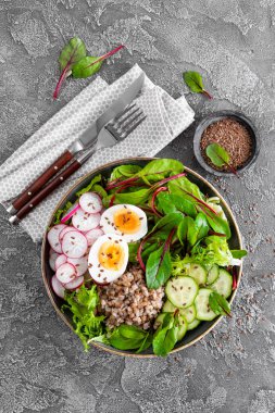 Buda kase yemek buğday lapası, haşlanmış yumurta, taze sebze salatası, turp, salatalık, marul ve pazı yaprakları. Sağlıklı öğle yemeği menüsü. Üstten Görünüm