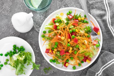 Çiğ havuç, yeşil bezelye, Mısır, tatlı biber ve marul ile taze sebze salatası. Sağlıklı vegan, vejetaryen öğle yemeği menüsü. Üstten Görünüm