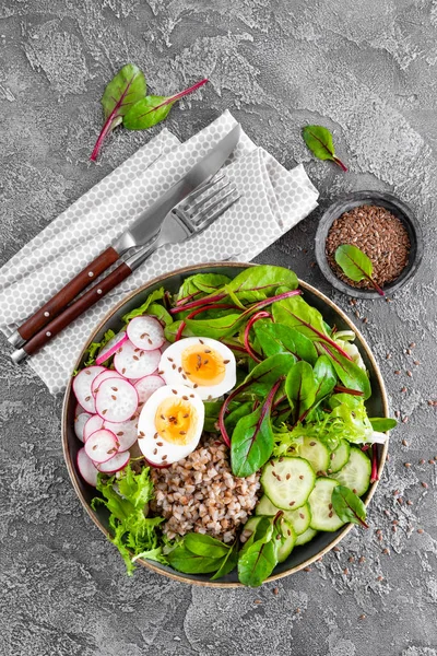 Buda kase yemek buğday lapası, haşlanmış yumurta, taze sebze salatası, turp, salatalık, marul ve pazı yaprakları. Sağlıklı öğle yemeği menüsü. Üstten Görünüm