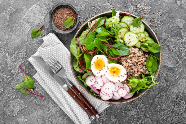 Buda kase yemek buğday lapası, haşlanmış yumurta, taze sebze salatası, turp, salatalık, marul ve pazı yaprakları. Sağlıklı öğle yemeği menüsü. Üstten Görünüm