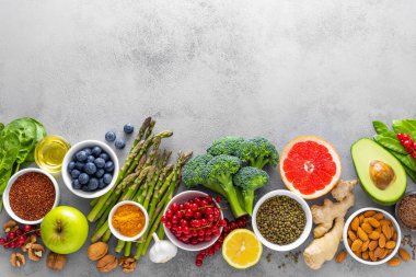 Sağlıklı gıda arka plan, ıspanak, quinoa, elma, yaban mersini, kuşkonmaz, zerdeçal, frenk üzümü, brokoli, mung fasulye, ceviz, greyfurt, zencefil, avokado, badem, limon, yeşil bezelye ve goji, üstten görünüm