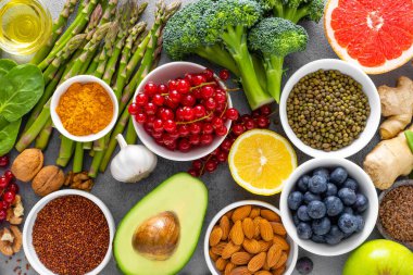 Sağlıklı gıda arka plan, ıspanak, quinoa, elma, yaban mersini, kuşkonmaz, zerdeçal, frenk üzümü, brokoli, mung fasulye, ceviz, greyfurt, zencefil, avokado, badem, limon, yeşil bezelye ve goji, üstten görünüm