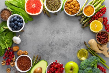 Sağlıklı gıda arka plan, ıspanak, quinoa, elma, yaban mersini, kuşkonmaz, zerdeçal, frenk üzümü, brokoli, mung fasulye, ceviz, greyfurt, zencefil, avokado, badem, limon, yeşil bezelye ve goji, üstten görünüm