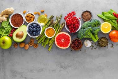 Healthy food background, spinach, quinoa, apple, blueberry, asparagus, turmeric, red currant, broccoli, mung bean, walnuts, grapefruit, ginger, avocado, almond, lemon, green peas and goji, top view clipart